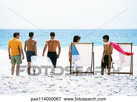 Adults standing on beach, rear view View Large Photo Image Stock Photo - Adults standing on beach, rear view. Fotosearch