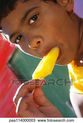 Stock Image - Boy eating popsicle, close-up. Fotosearch