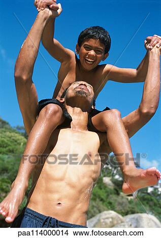 Picture - Boy sitting on man's shoulders, close-up. Fotosearch