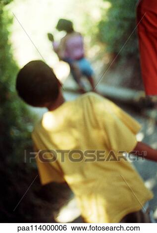 Child walking on path behind woman holding baby, rear view, blurred View Large Photo Image Stock Photograph - Child walking on path behind woman holding baby, rear view, blurred. Fotosearch
