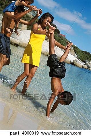 Family playing in water at beach View Large Photo Image Stock Photo - Family playing in water at beach. Fotosearch