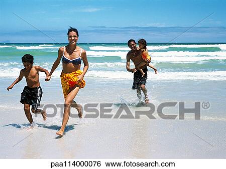 Family running on beach View Large Photo Image Stock Photograph - Family running on beach. Fotosearch