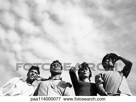 Four adults looking, low angle view, b&w View Large Photo Image Stock Photo - Four adults looking, low angle view, b&w. Fotosearch