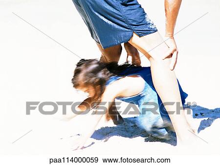 Girl crawling through man's legs on beach, blurred View Large Photo Image Stock Photo - Girl crawling through man's legs on beach, blurred. Fotosearch