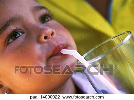 Stock Image - Girl drinking from straw, close-up. Fotosearch