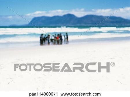 Group of people standing on beach in distance, blurred View Large Photo Image Stock Image - Group of people standing on beach in distance, blurred. Fotosearch