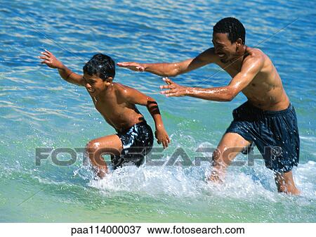 Man and son playing in sea View Large Photo Image Stock Photo - Man and son playing in sea. Fotosearch