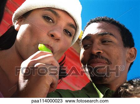 Man and woman, woman eating ice cream, close-up, low angle view View Large Photo Image Stock Image - Man and woman, woman eating ice cream, close-up, low angle view. Fotosearch