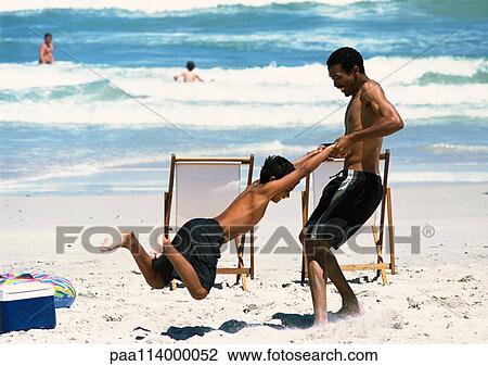 Man swinging boy on beach View Large Photo Image Stock Image - Man swinging boy on beach. Fotosearch