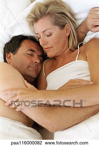 Couple in bed sleeping, in each other's arms View Large Photo Image Stock Image - Couple in bed sleeping, in each other's arms. Fotosearch