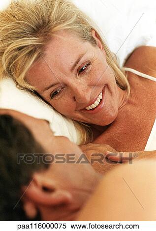 Couple lying in bed face to face, close-up View Large Photo Image Stock Photography - Couple lying in bed face to face, close-up. Fotosearch