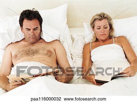Couple lying in bed, reading View Large Photo Image Stock Image - Couple lying in bed, reading. Fotosearch