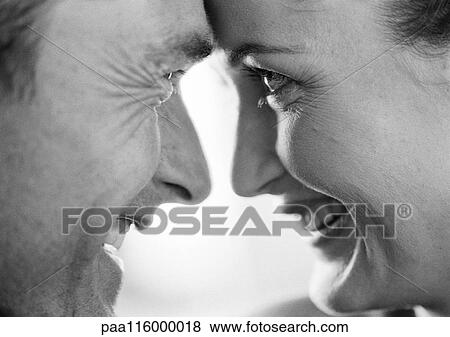 Stock Photo - Couple smiling face to face, close-up, b&w. Fotosearch