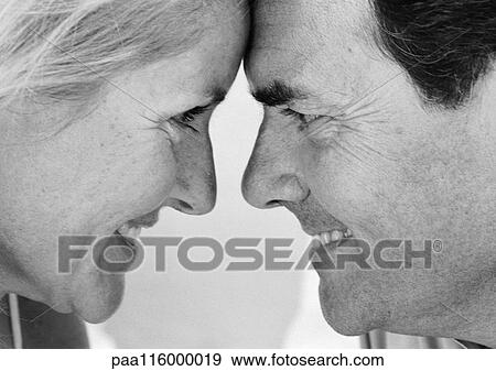 Stock Photo - Couple smiling face to face, close-up, b&w. Fotosearch