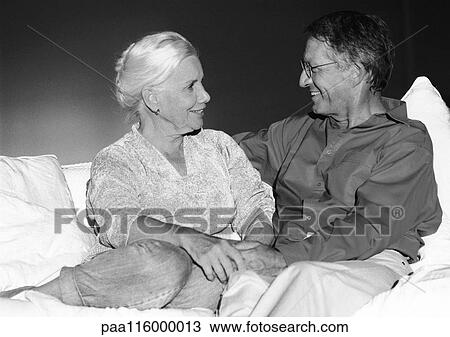 Stock Image - Mature couple sitting on couch, b&w. Fotosearch