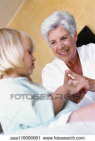 Mature woman smiling at little girl View Large Photo Image Stock Image - Mature woman smiling at little girl. Fotosearch