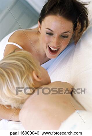 Mother and baby playing on bed, close-up View Large Photo Image Stock Photograph - Mother and baby playing on bed, close-up. Fotosearch
