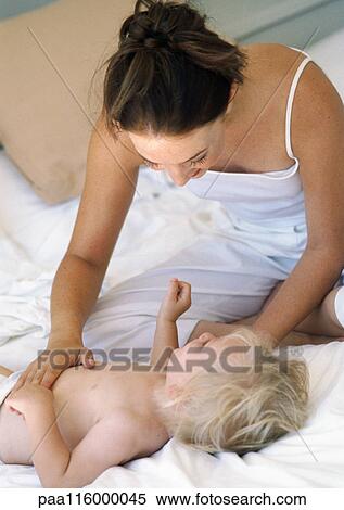 Mother touching baby's stomach View Large Photo Image Stock Photography - Mother touching baby's stomach. Fotosearch