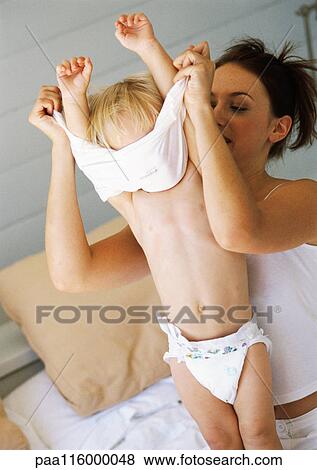 Mother undressing baby View Large Photo Image Stock Photo - Mother undressing baby. Fotosearch