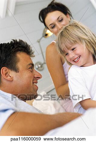 Parents and daughter smiling, low angle view View Large Photo Image Stock Photo - Parents and daughter smiling, low angle view. Fotosearch
