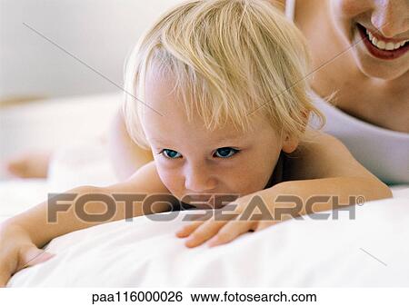 Woman and baby lying on bed, close-up View Large Photo Image Stock Photograph - Woman and baby lying on bed, close-up. Fotosearch