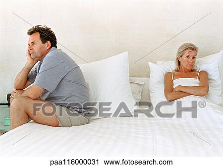 Woman in bed with arms crossed, man sitting on side of bed View Large Photo Image Stock Image - Woman in bed with arms crossed, man sitting on side of bed. Fotosearch