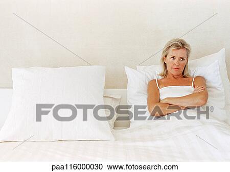 Woman lying in bed, arms folded over chest View Large Photo Image Stock Image - Woman lying in bed, arms folded over chest. Fotosearch