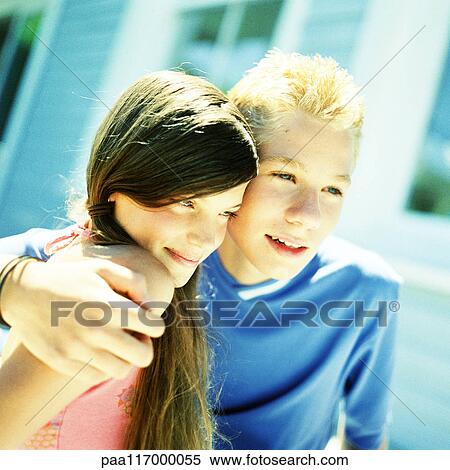 Stock Photography - Boy with arm around girl, outside. Fotosearch