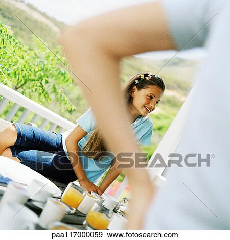 Stock Photo - Girl having breakfast outside. Fotosearch