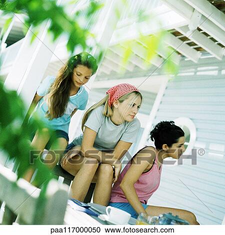 Girls and young woman sitting outside View Large Photo Image Stock Image - Girls and young woman sitting outside. Fotosearch