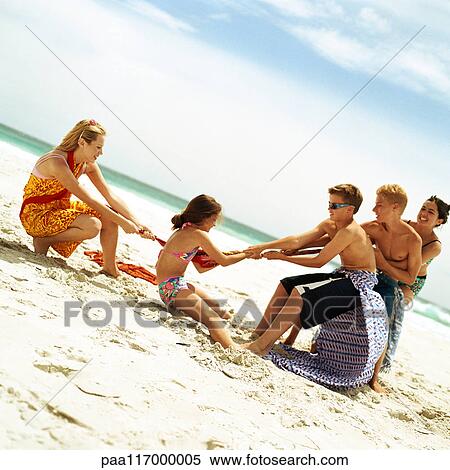 Group of people playing tug of war at the beach View Large Photo Image Stock Photography - Group of people playing tug of war at the beach. Fotosearch