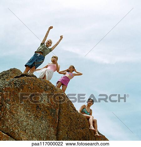 People standing on rock, low angle view View Large Photo Image Stock Image - People standing on rock, low angle view. Fotosearch