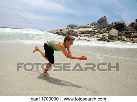Teenage boy running on beach View Large Photo Image Stock Image - Teenage boy running on beach. Fotosearch