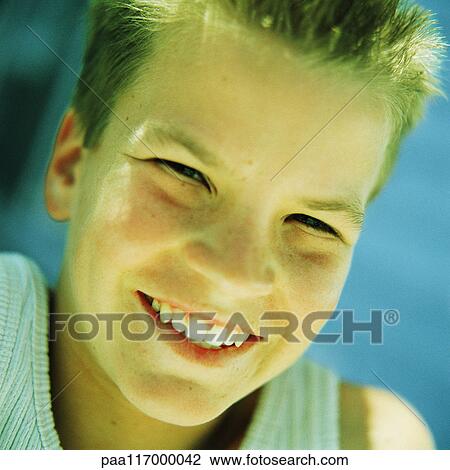 Stock Image - Teenage boy's face, smiling, portrait. Fotosearch