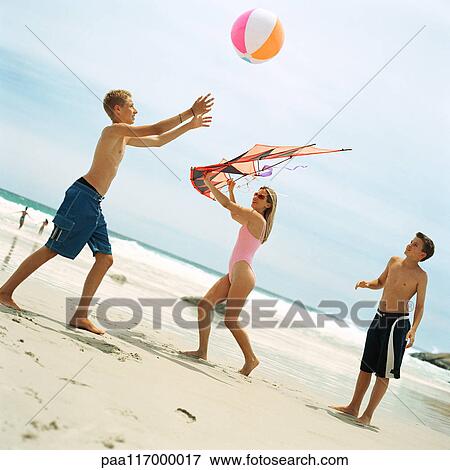 Two boys playing with beach ball, woman holding kite View Large Photo Image Stock Photo - Two boys playing with beach ball, woman holding kite. Fotosearch