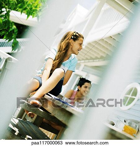 Stock Image - Two girls on porch. Fotosearch