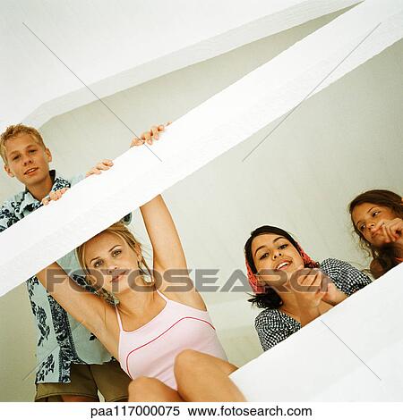 Young people in loft looking into camera, low angle view View Large Photo Image Stock Photography - Young people in loft looking into camera, low angle view. Fotosearch