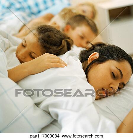Young people lying in bed, sleeping View Large Photo Image Picture - Young people lying in bed, sleeping. Fotosearch