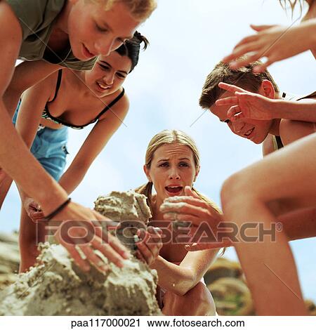 Young people making sandcastle, low angle view View Large Photo Image Stock Image - Young people making sandcastle, low angle view. Fotosearch