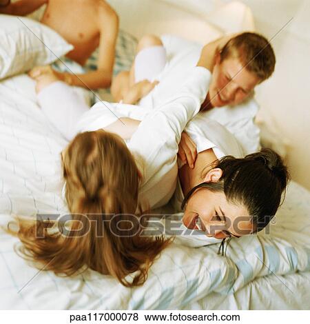 Young people play fighting on bed, smiling View Large Photo Image Stock Photo - Young people play fighting on bed, smiling. Fotosearch