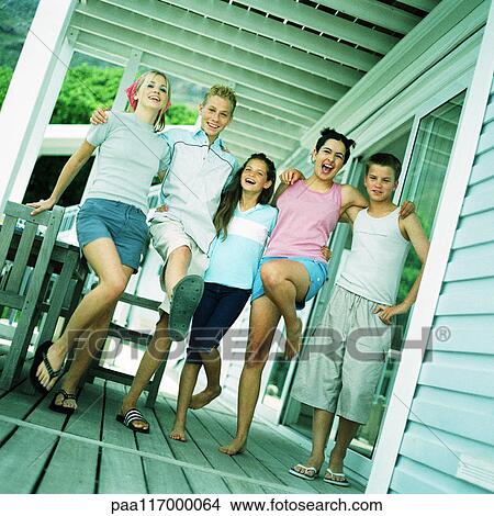 Picture - Young people standing with arms around each other's shoulders on porch. Fotosearch