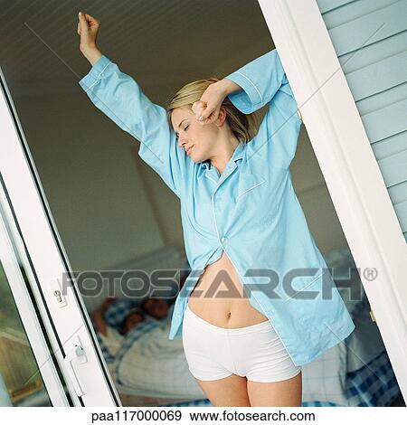 Young woman stretching in doorway View Large Photo Image Stock Photo - Young woman stretching in doorway. Fotosearch
