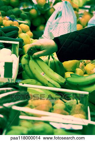 Hand choosing bananas from among produce, close-up View Large Photo Image Picture - Hand choosing bananas from among produce, close-up. Fotosearch