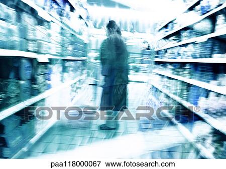 Person standing in aisle in supermarket, blurred View Large Photo Image Stock Photo - Person standing in aisle in supermarket, blurred. Fotosearch
