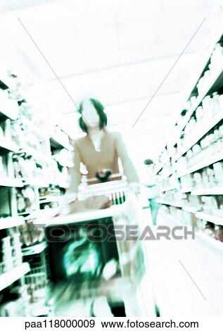 Woman pushing shopping cart in grocery store, blurred View Large Photo Image Stock Photo - Woman pushing shopping cart in grocery store, blurred. Fotosearch