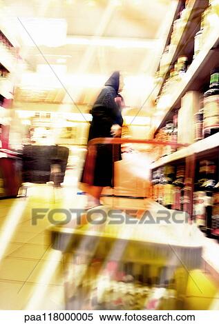 Woman standing in supermarket, blurred View Large Photo Image Stock Photography - Woman standing in supermarket, blurred. Fotosearch