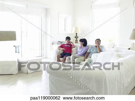 Couple and teenage boy sitting on sofa View Large Photo Image Stock Image - Couple and teenage boy sitting on sofa. Fotosearch