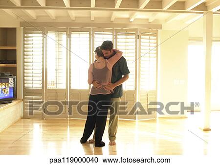 Stock Image - Couple hugging in room. Fotosearch