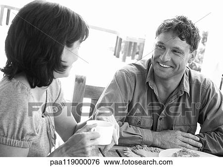 Stock Photograph - Couple sitting at table outside, b&w. Fotosearch