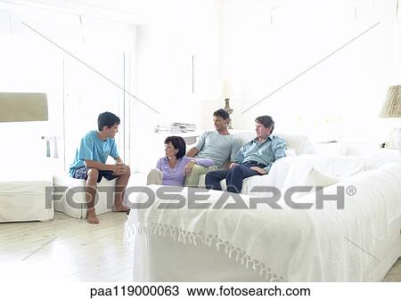 Stock Image - Family sitting in living room. Fotosearch